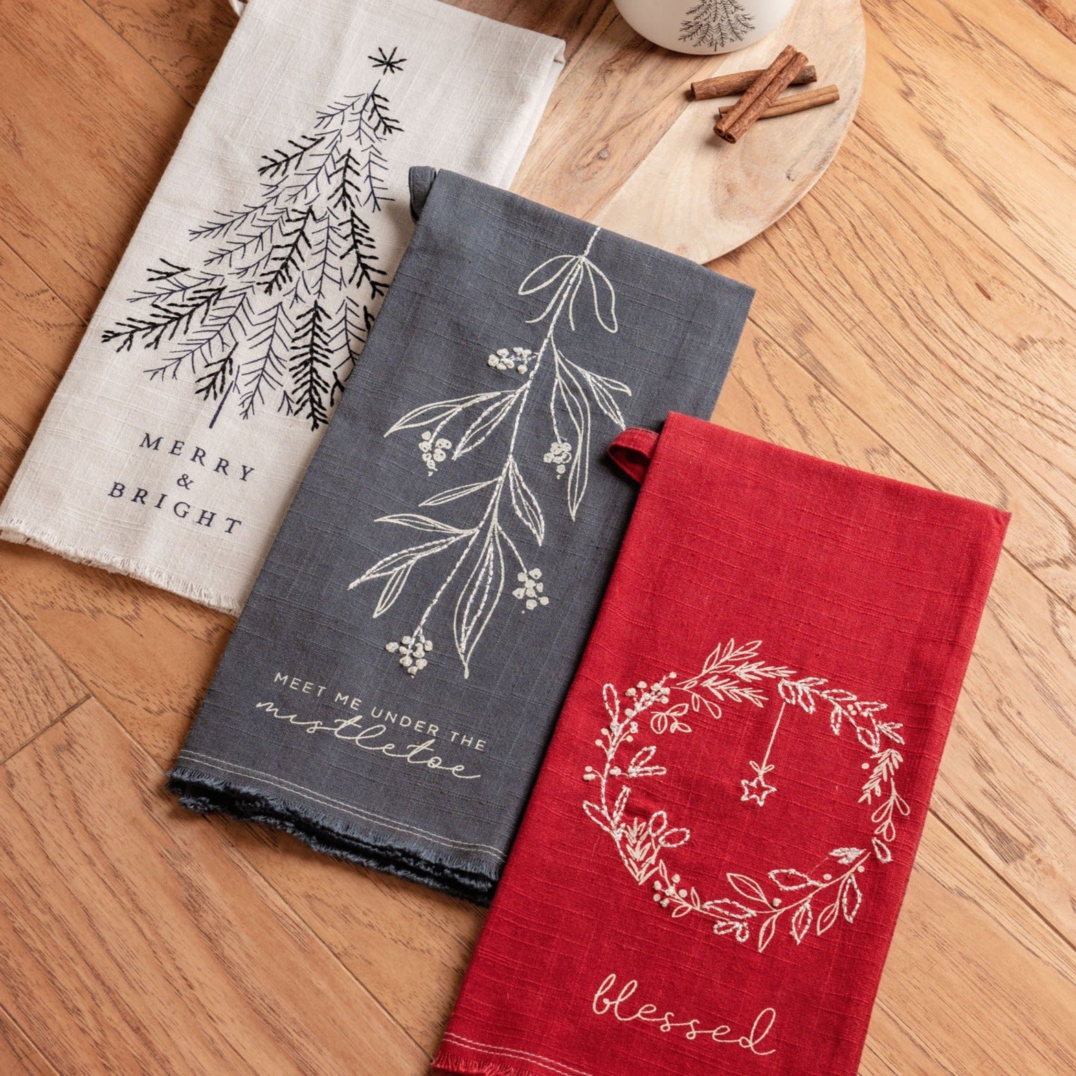 Embroidered cotton tea towels on a table.