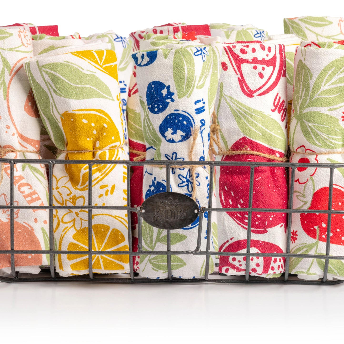 Fruit basket tea towels in a basket with a white background.