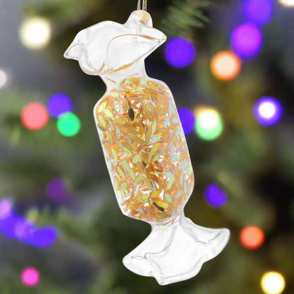 Rectangle Confetti Wrapped Candy Gold Ornament with holiday lighting in the background.