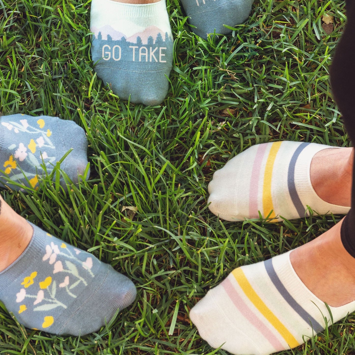 People wearing no show socks in grass.