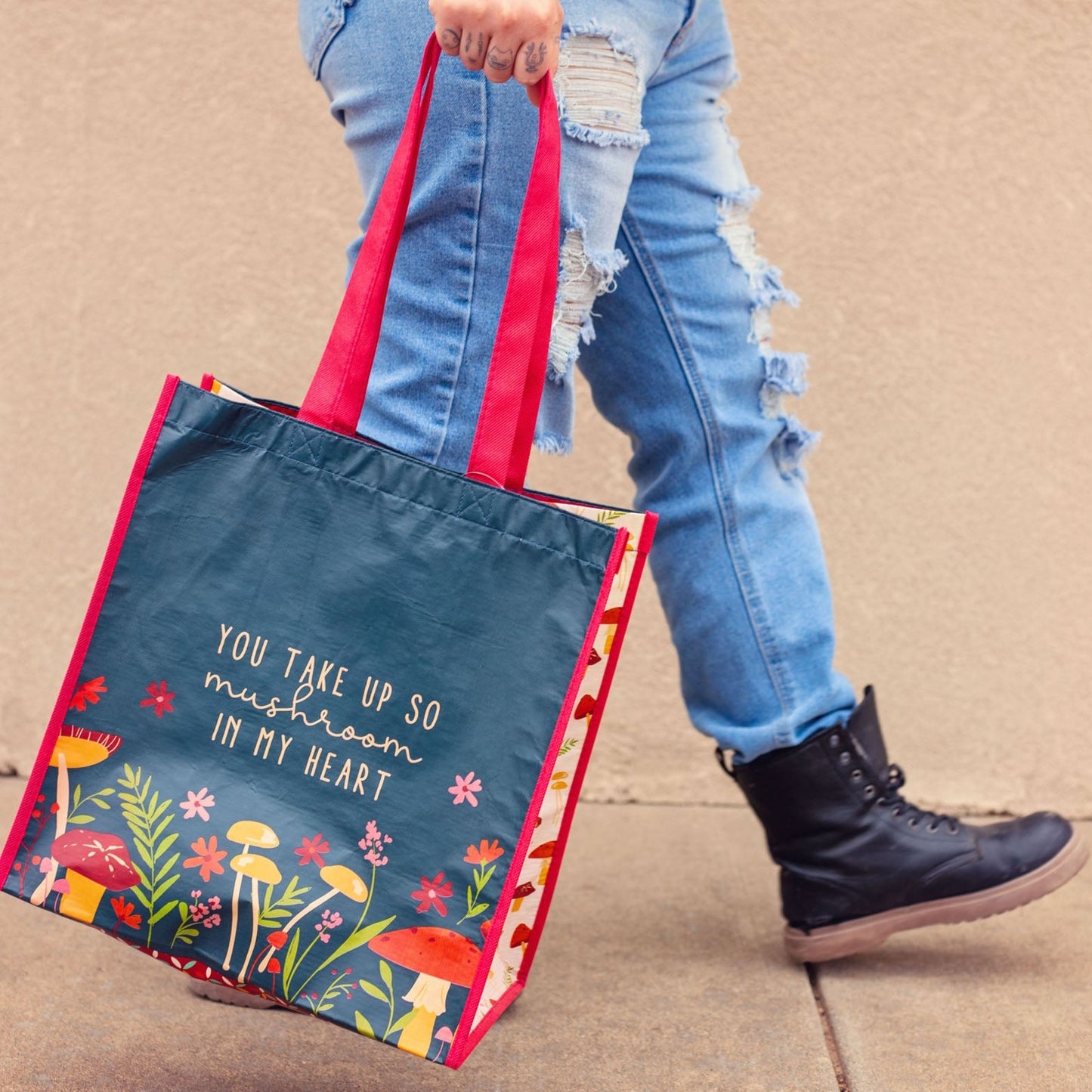 Person carrying Mushroom Recycled Large Gift Bag with a tan background.
