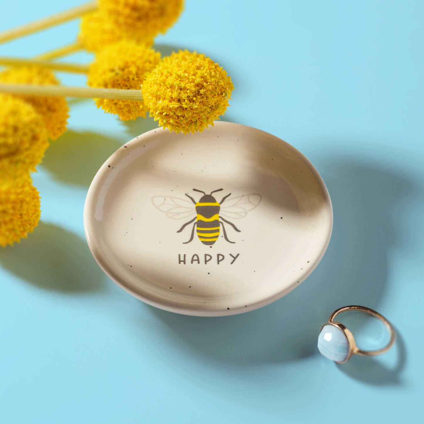 Bee Reese Trinket Tray on a blue background.