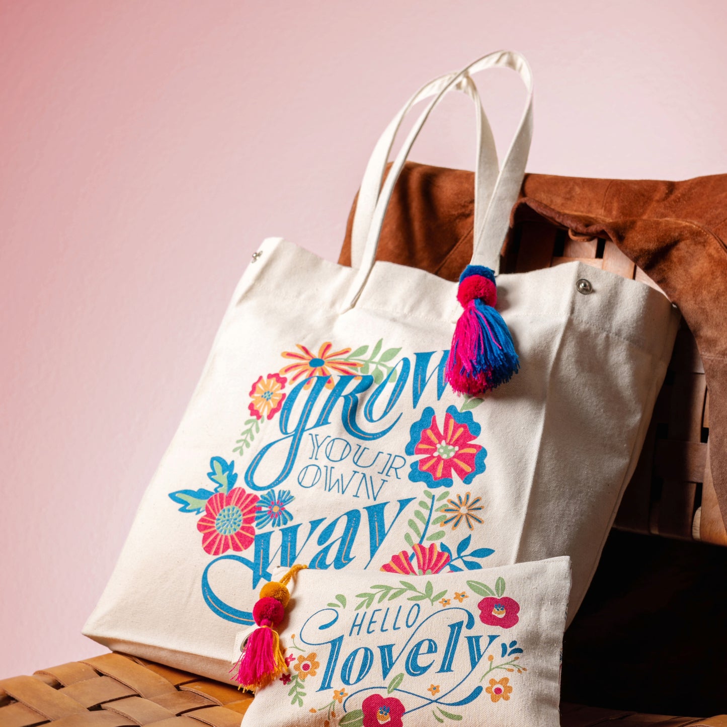 Grow Your Own Way Canvas Tote Bag on a chair with a pink background.