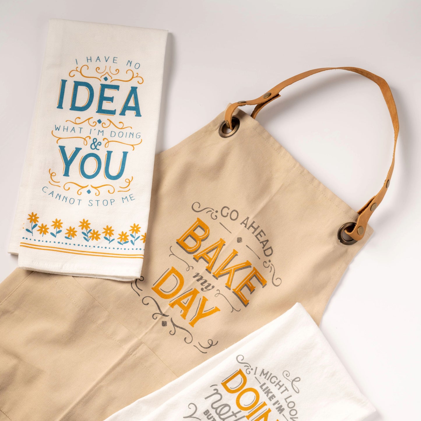 cheeky tea towels and apron against a white background
