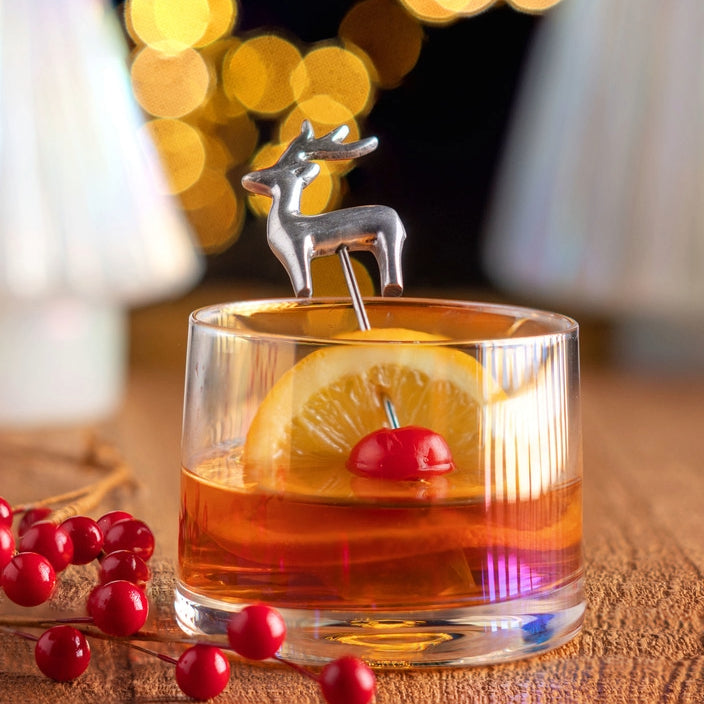 Deer Holiday Cocktail Pick in a glass on a table.