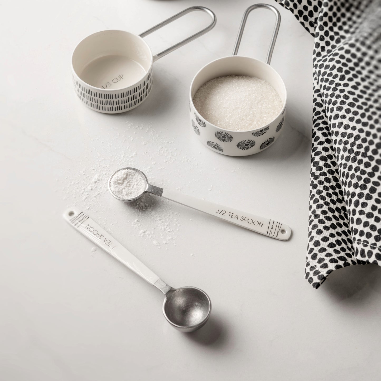 Milo Measuring Spoons on a white counter in use.