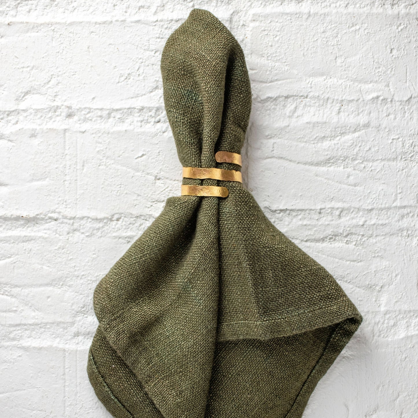 Gold Spiral Napkin Rings on a napkin against a white background.