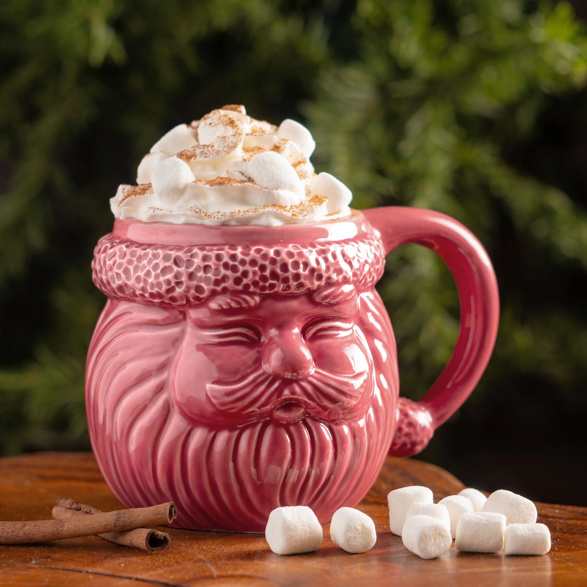 Pink Santa Mug on a table with marshmallows and cinnamon.