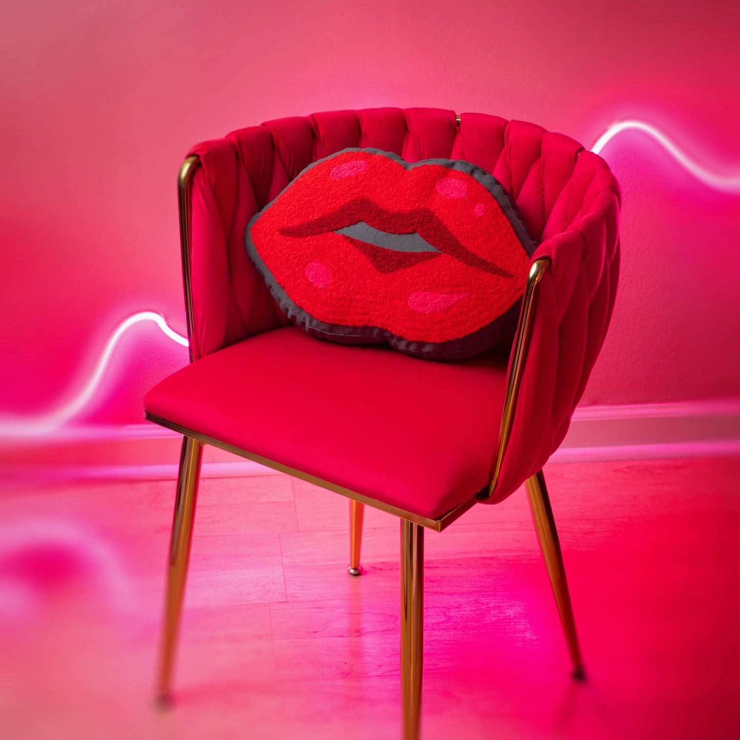 Lips Shaped Embroidered Pillow on a red chair with a pink background.