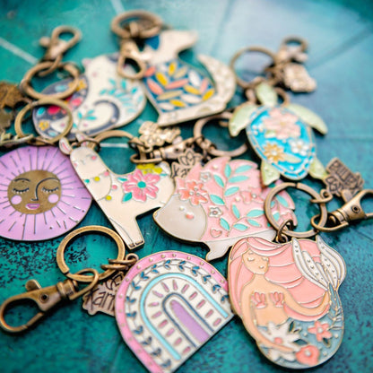 Enamel keychains on a green background. 
