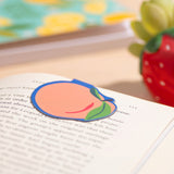 Peach magnetic bookmark on a book.