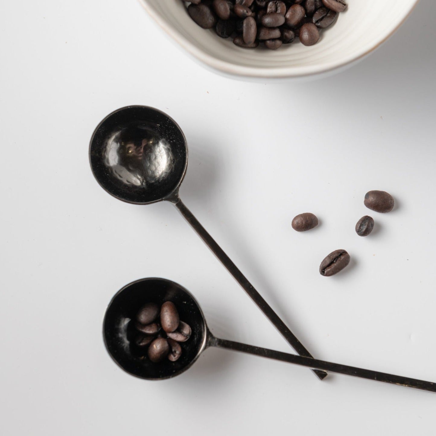 Black metal spoons with coffee beans