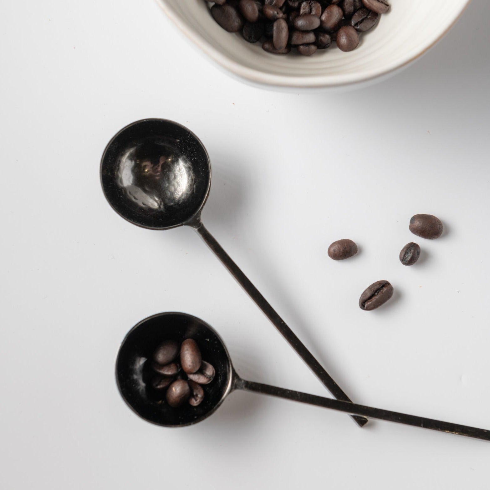 Black metal spoons with coffee beans