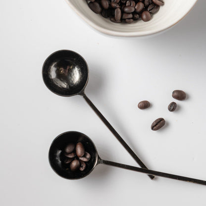 Black metal spoons with coffee beans