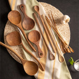 Bali teak curved ladle with other spoons on a placemat