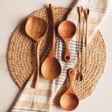 Bali teak curved spoon long with other spoons on a placemat