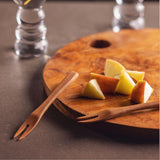 Bali teak fruit forks on a cutting board.