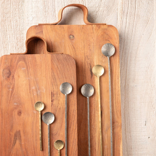 Barcelona serve boards with handles on a table with spoons.