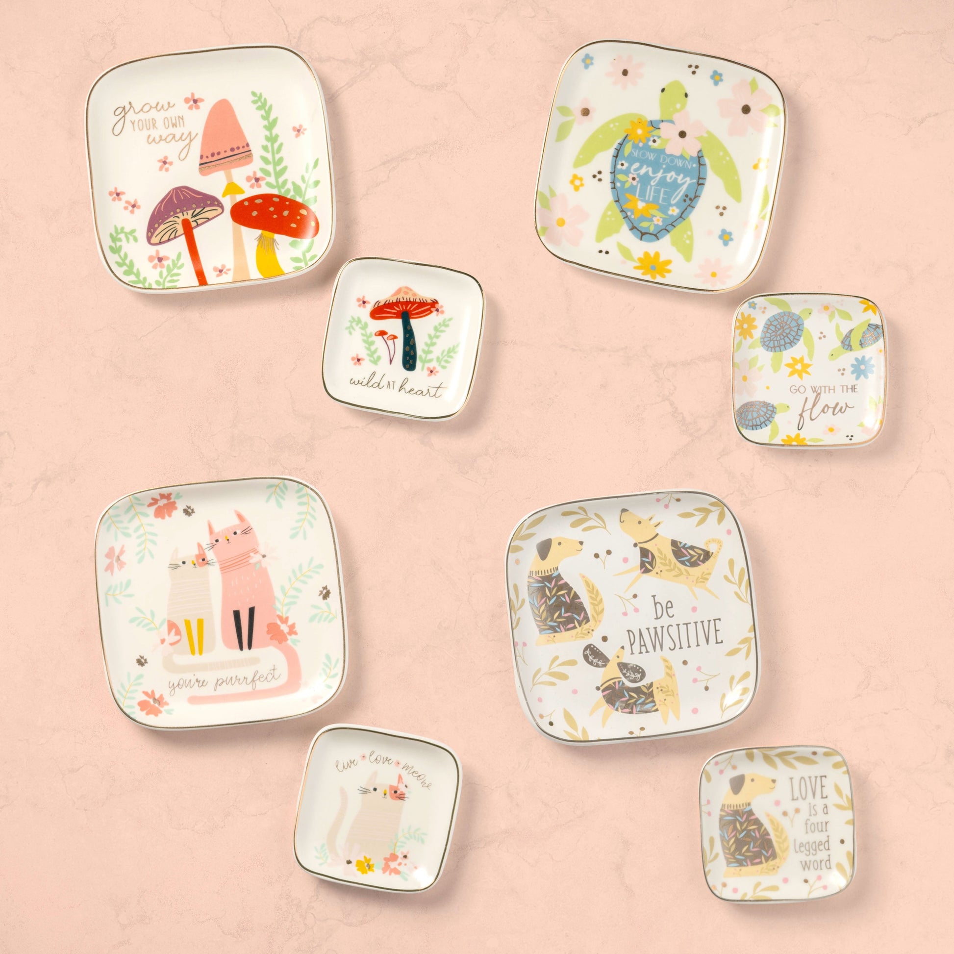 Small and large flora trinket trays against a pink background. 