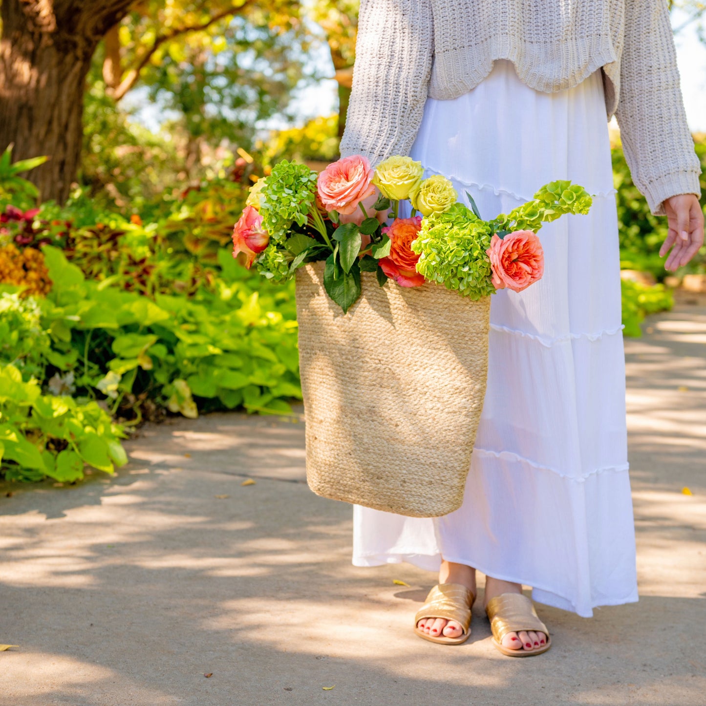 Carrying the Jute Wall Basket with flowers on a path. 
