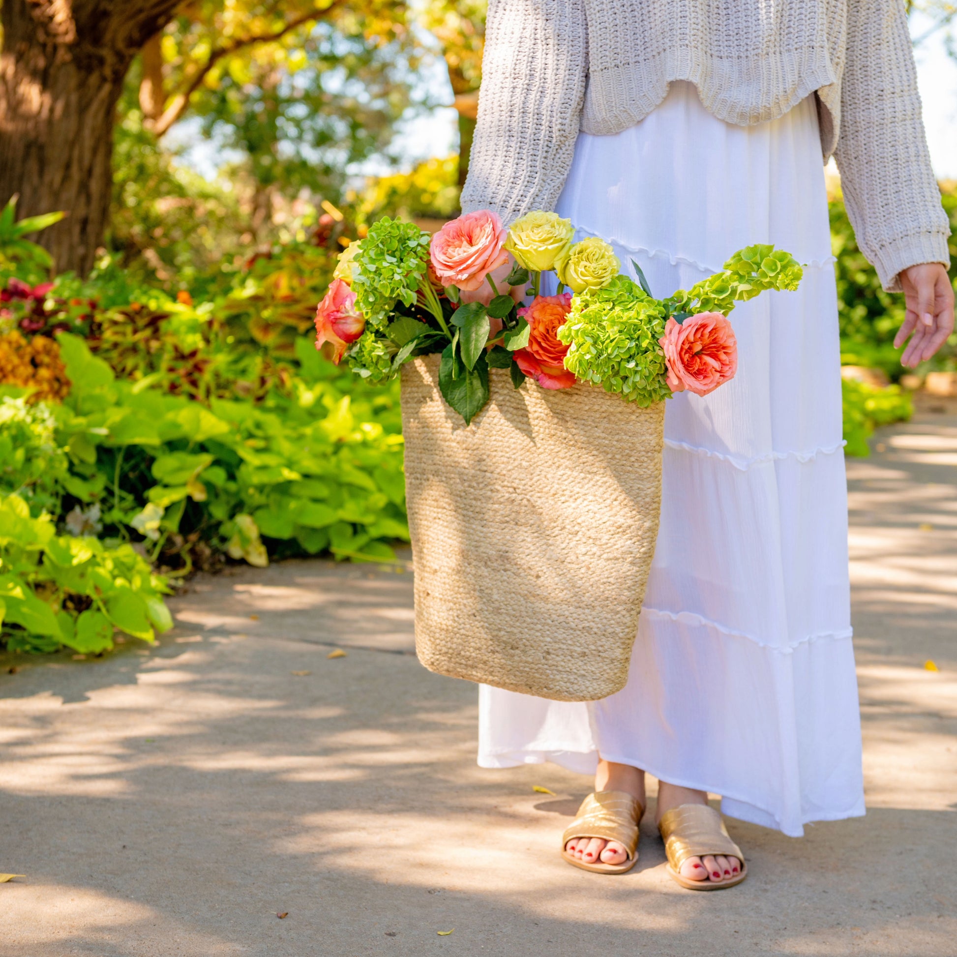 Carrying the Jute Wall Basket with flowers on a path. 