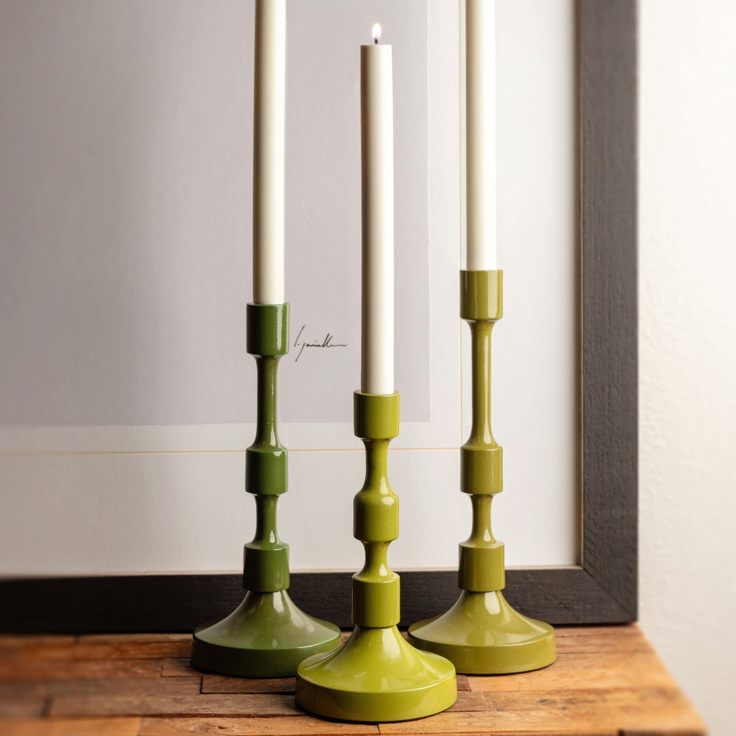 Metal taper candlestick holders on a wooden table. 