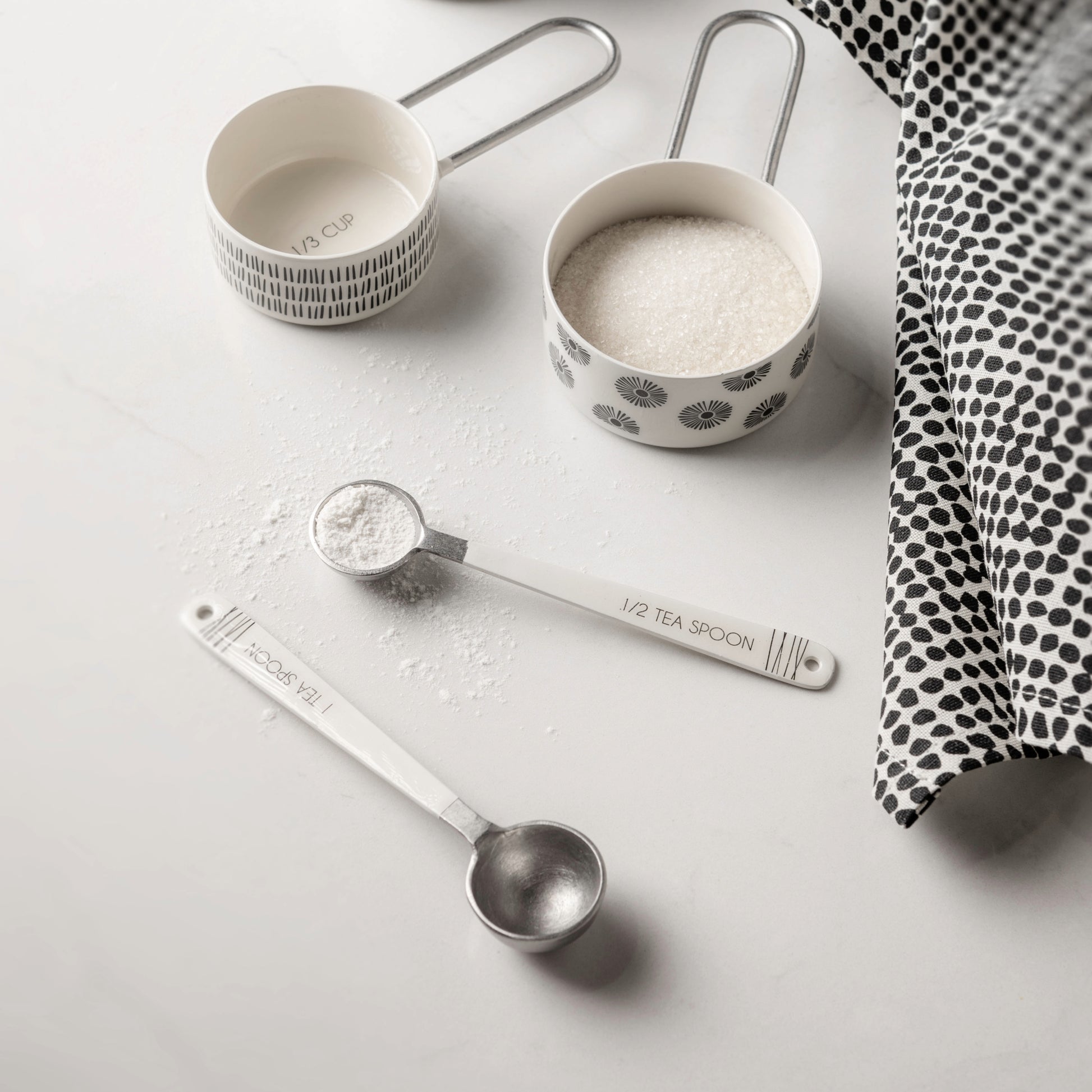 Milo Measuring Spoons on a white counter in use. 