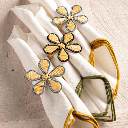 Raffia Floral Napkin Rings on a table and on napkins. 
