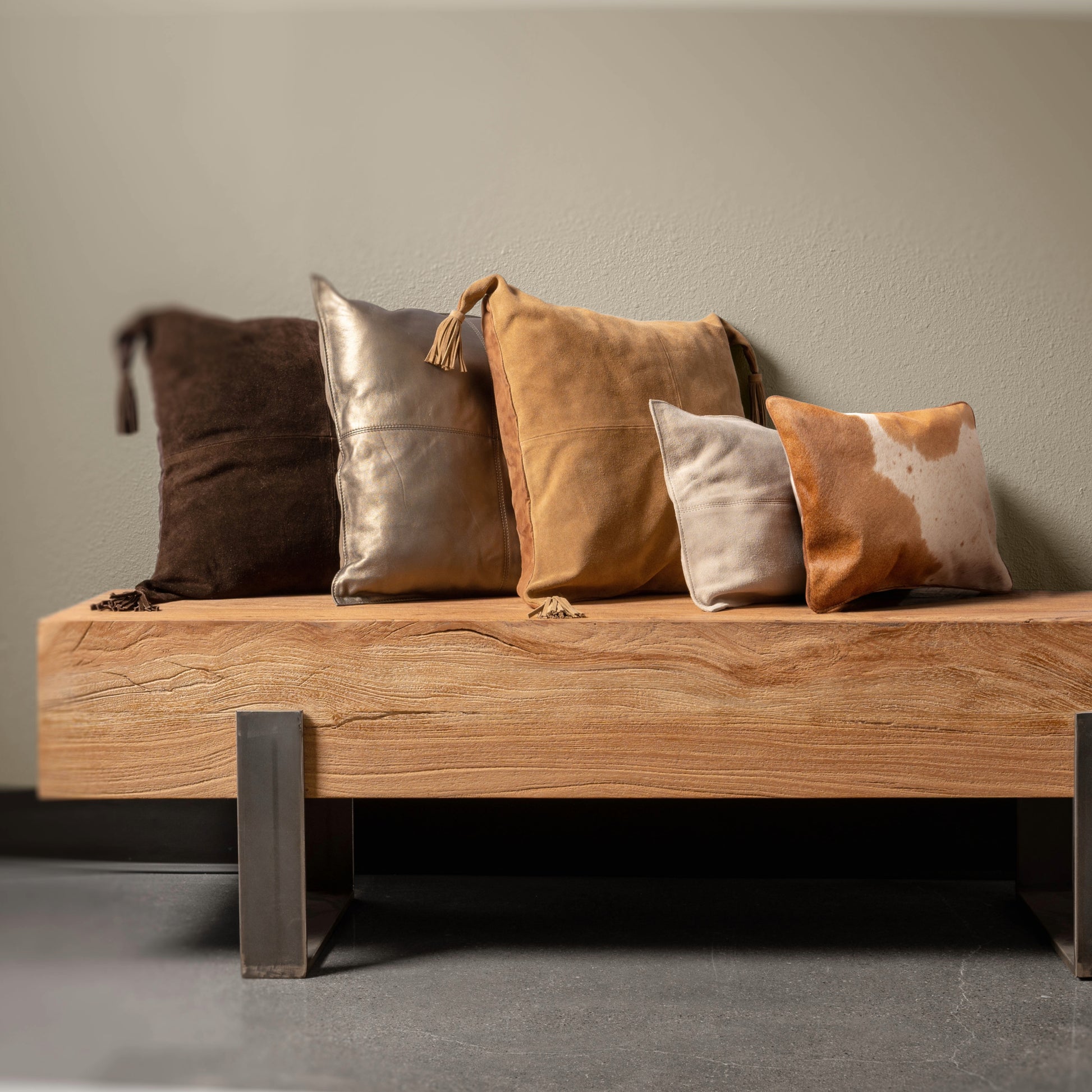 Bronco Suede Tassel Square Pillow on a bench. 