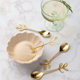 Scalloped oval dish and vine appetizer spoons on a counter.