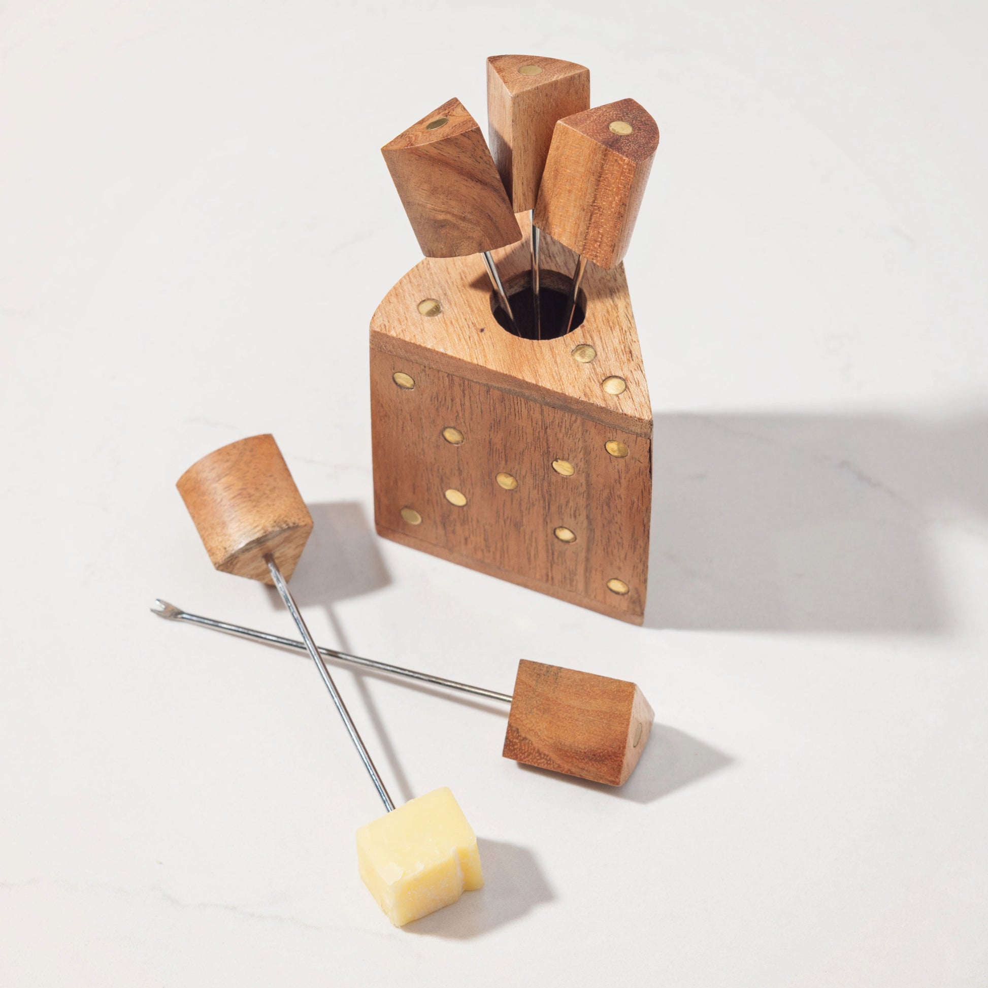 Wood Cheese Picks on a counter, two picks laying next to it. 