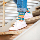 Someone wearing pick queen crew socks while walking down stairs.