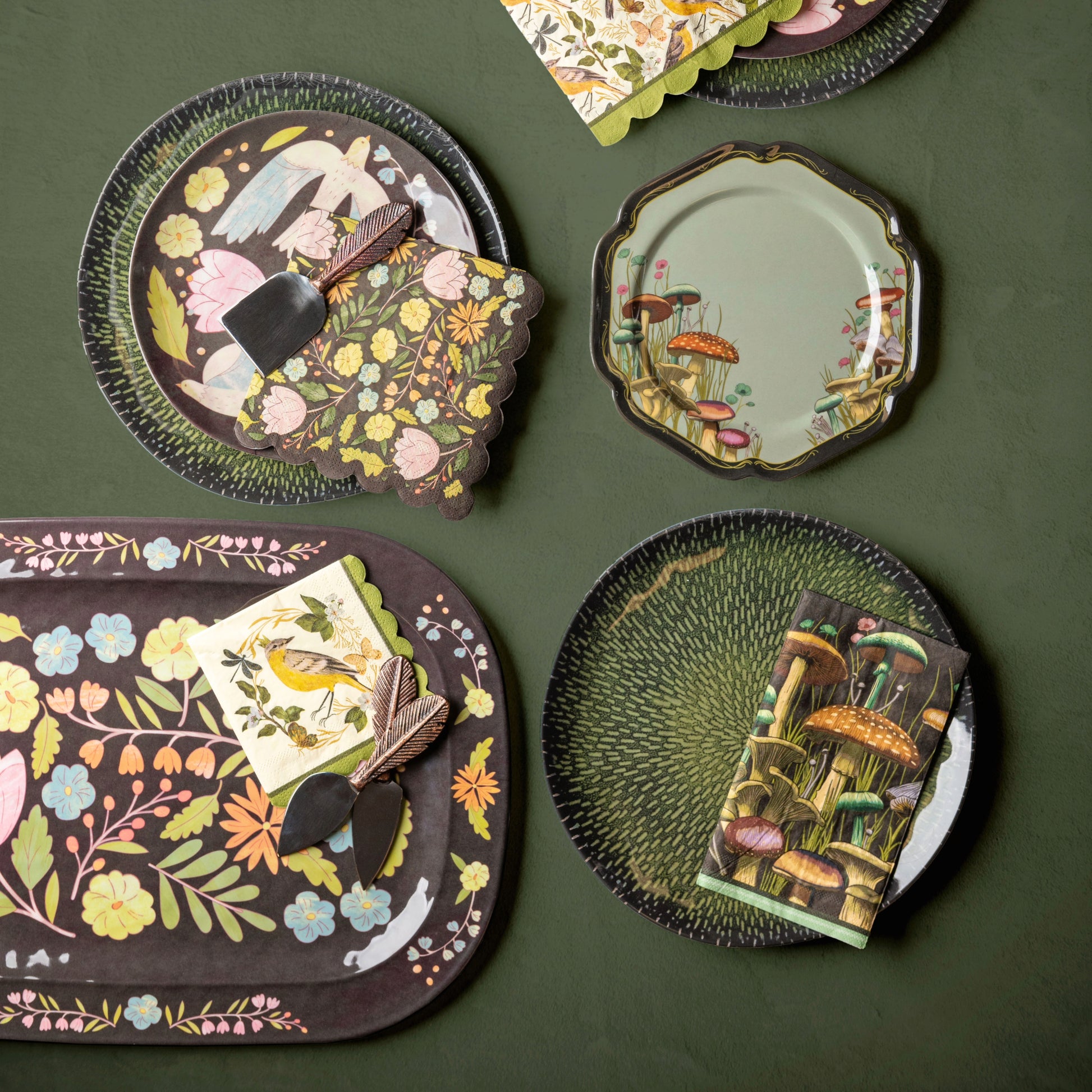 Melamine serving tray and plates and paper napkins on a green background. 