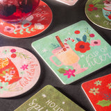 Holiday paper coasters on a black table.