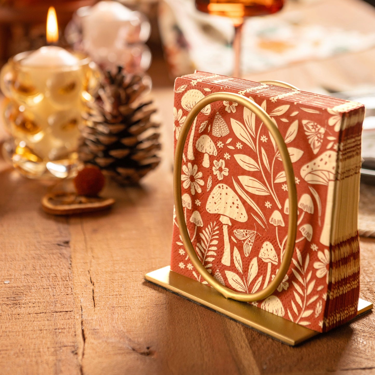 Mushroom cocktail napkins n gold napkin holder on a table. 