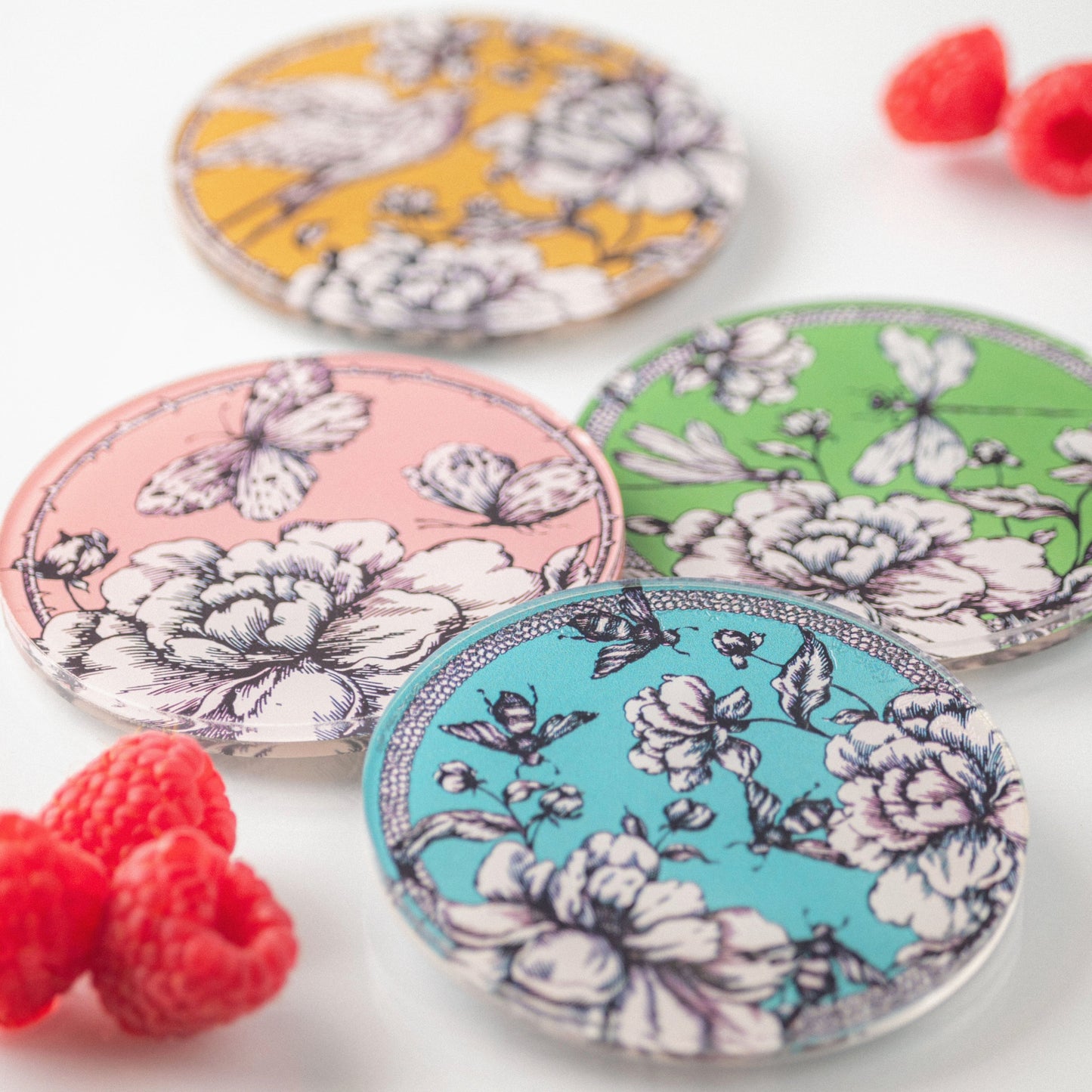 Austen Acrylic Coasters on a white table with raspberries. 